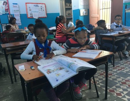 Schulkinder sitzen in einem Klassenraum und machen Schulaufgaben
